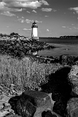 Fort Pickering Lighthouse Along Rocky Shoreline -BW